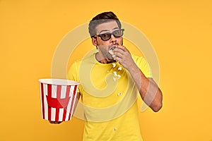 Shocked scared young man in casual clothes 3d glasses isolated on yellow background. People emotions in cinema, lifestyle concept