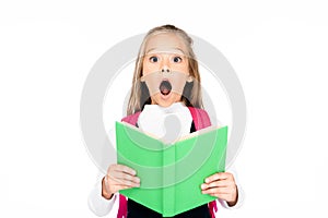 shocked schoolgirl holding book while looking at camera isolated on white.