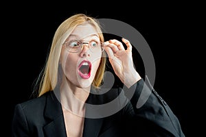 Shocked Secretary in glasses deluged by documents. Thoughtful young Secretary holding folders on black background