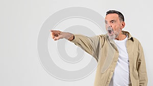 Shocked senior man pointing with an open mouth