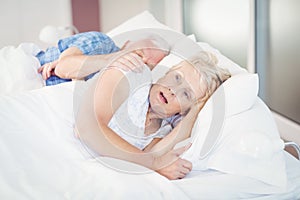 Shocked senior woman sleeping besides man on bed