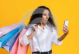 Shocked shopaholic woman checking online banking money balance in app on smartphone