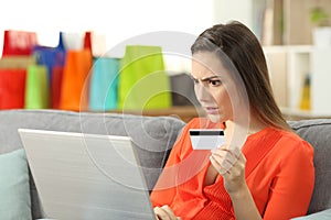 Shocked shopper buying online with credit card photo