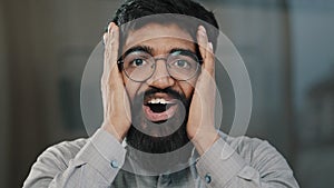 Shocked smiling arabian man professional agent businessman in eyeglasses surprised good news amazing discover feel