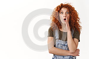 Shocked and speechless cute modern redhead curly-haired girl, gasping amazed, drop jaw fascinated and impressed, stare