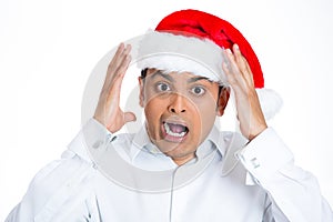 A shocked and stressed young man in santa hat