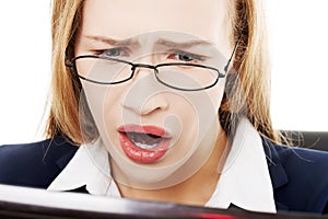 Shocked, surprised business woman sitting in front of laptop.