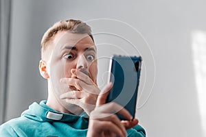 Shocked and surprised man looking smartphone