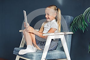 Shocked surprised pre teen girl playing on tablet pc open her mouth in the living room at home. family activity concept