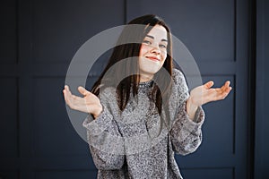 Shocked surprised smiling woman with spread hands