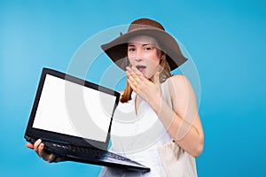 Shocked surprised woman wearing white t-shirts holding hand closing mouth with a laptop pc computer, blank screen mockup