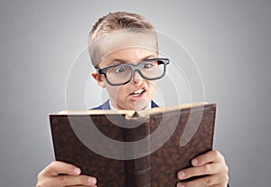 Shocked and surprised young executive businessman boy reading a book