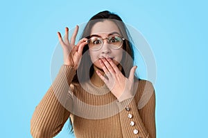 Shocked teen girl adjusting glasses