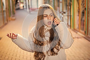 shocked teen girl having phone call in the street. teen girl having phone call outdoor.