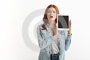 Shocked teen girl showing digital tablet