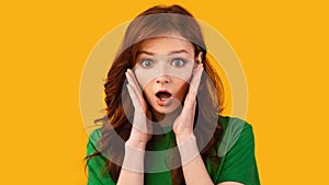 Shocked Teen Girl Touching Face Looking At Camera, Yellow Background