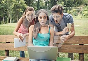 Shocked teenagers using a laptop