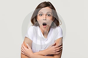 Shocked terrified young woman feeling afraid isolated on grey background