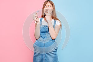 Shocked terrified young woman holds a pregnancy test