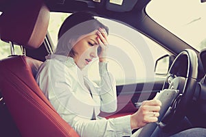 Shocked woman in car with papers