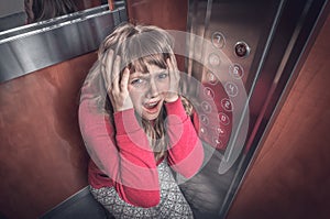 Shocked woman with claustrophobia in the moving elevator