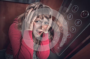 Shocked woman with claustrophobia in the moving elevator