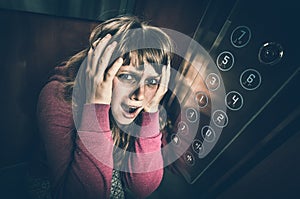 Shocked woman with claustrophobia in the moving elevator