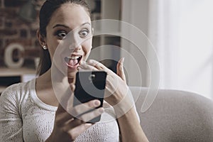 Shocked woman connecting with her smartphone