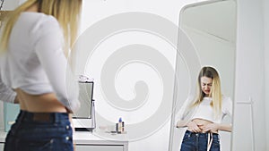 Shocked woman disappointed by extent of her waist