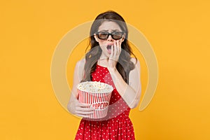 Shocked woman girl in red summer dress, 3d glasses isolated on yellow background. People lifestyle concept. Mock up copy