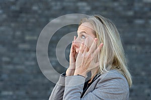 Shocked woman with her hands to her cheeks