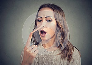 Shocked woman with long nose of liar photo