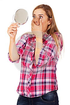 Shocked woman looking into mirror