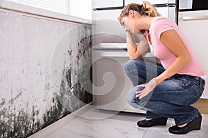 Shocked Woman Looking At Mold On Wall photo