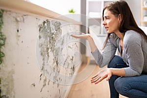 Shocked Woman Looking At Mold On Wall