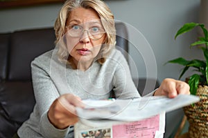 Shocked,woman reading newspaper, bad news.