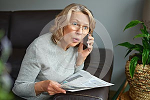 Shocked,woman reading newspaper, bad news.