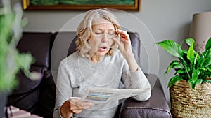 Shocked,woman reading newspaper, bad news.