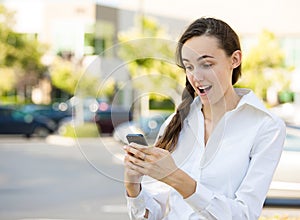 Shocked woman reading text message on smart phone