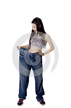Shocked woman trying her old jeans on studio
