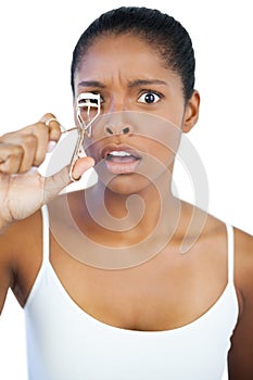 Shocked woman using curler for her eyelash