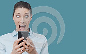 Shocked woman using a smartphone and connecting