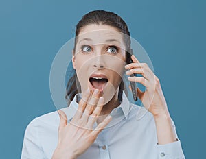 Shocked woman using a smartphone and connecting