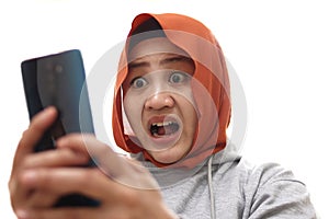 Shocked worried Asian muslim woman worried when reading bad news text message on her smart phone