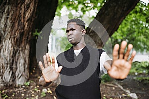 Shocked young 20s African man doing no stop sign with palms of hands