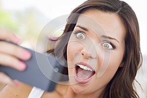 Shocked Young Adult Female Reading Cell Phone Outd photo