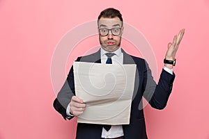 Shocked young businessman reading newspaper