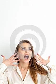 Shocked young caucasian woman with open mouth looking up and expresses surprise isolated over white background