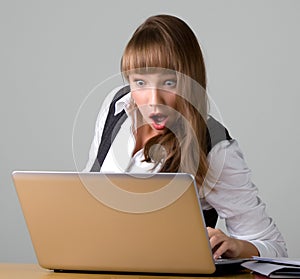 Shocked young girl is looking at a laptop