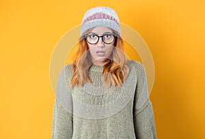 Shocked young girl with open mouth stare to you with popped eyes, isolated on yellow background. Astonished girl. Bad news